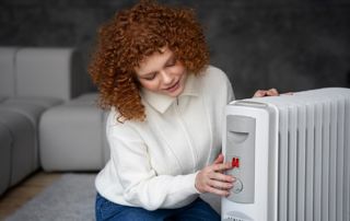 femme allumant son radiateur électrique