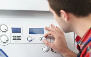 personne tournant un bouton sur un thermostat